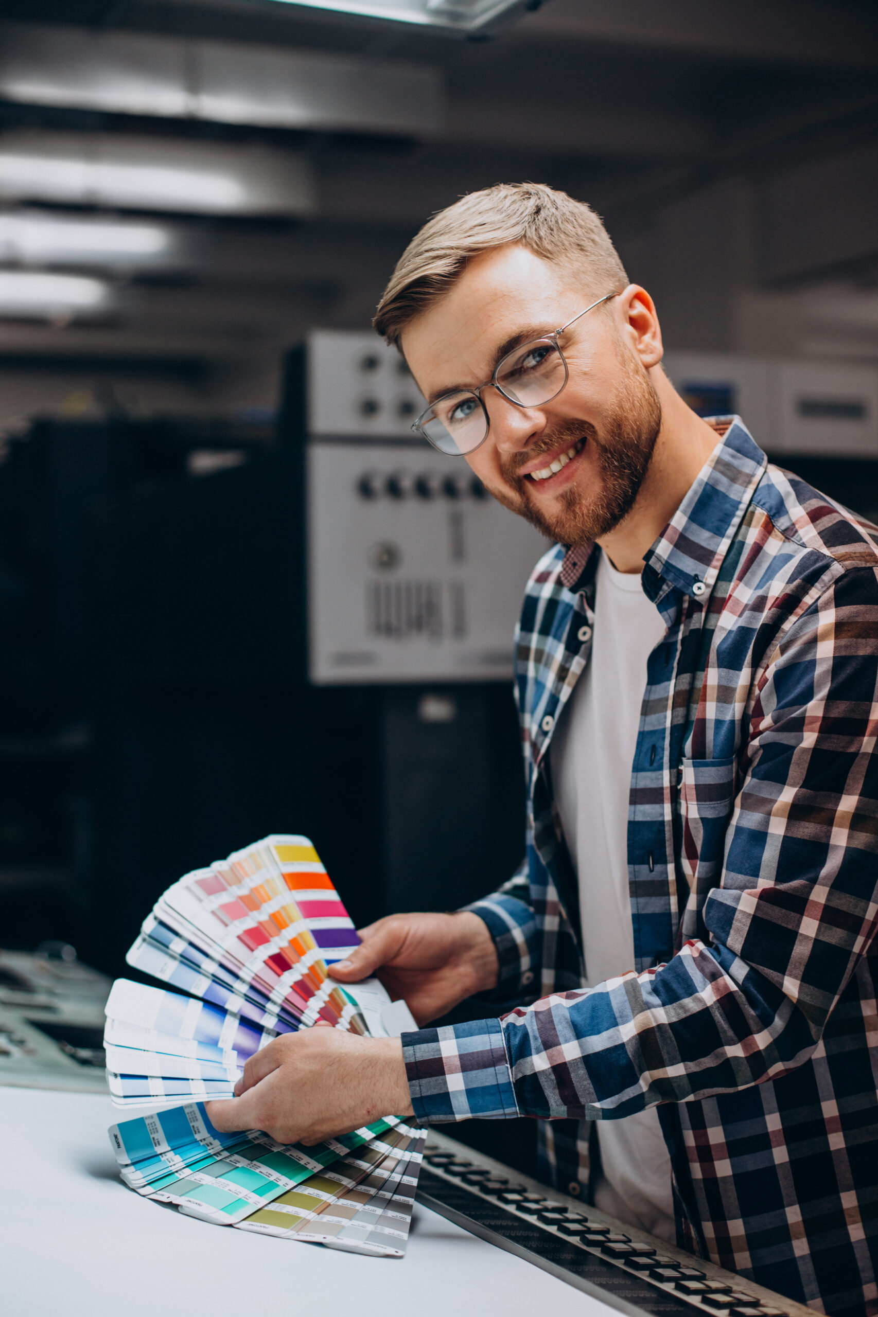man working in printing house with paper and paints